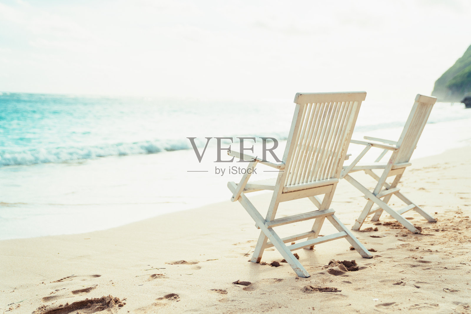 Bukit巴厘岛。海滩上的两把白色椅子照片摄影图片