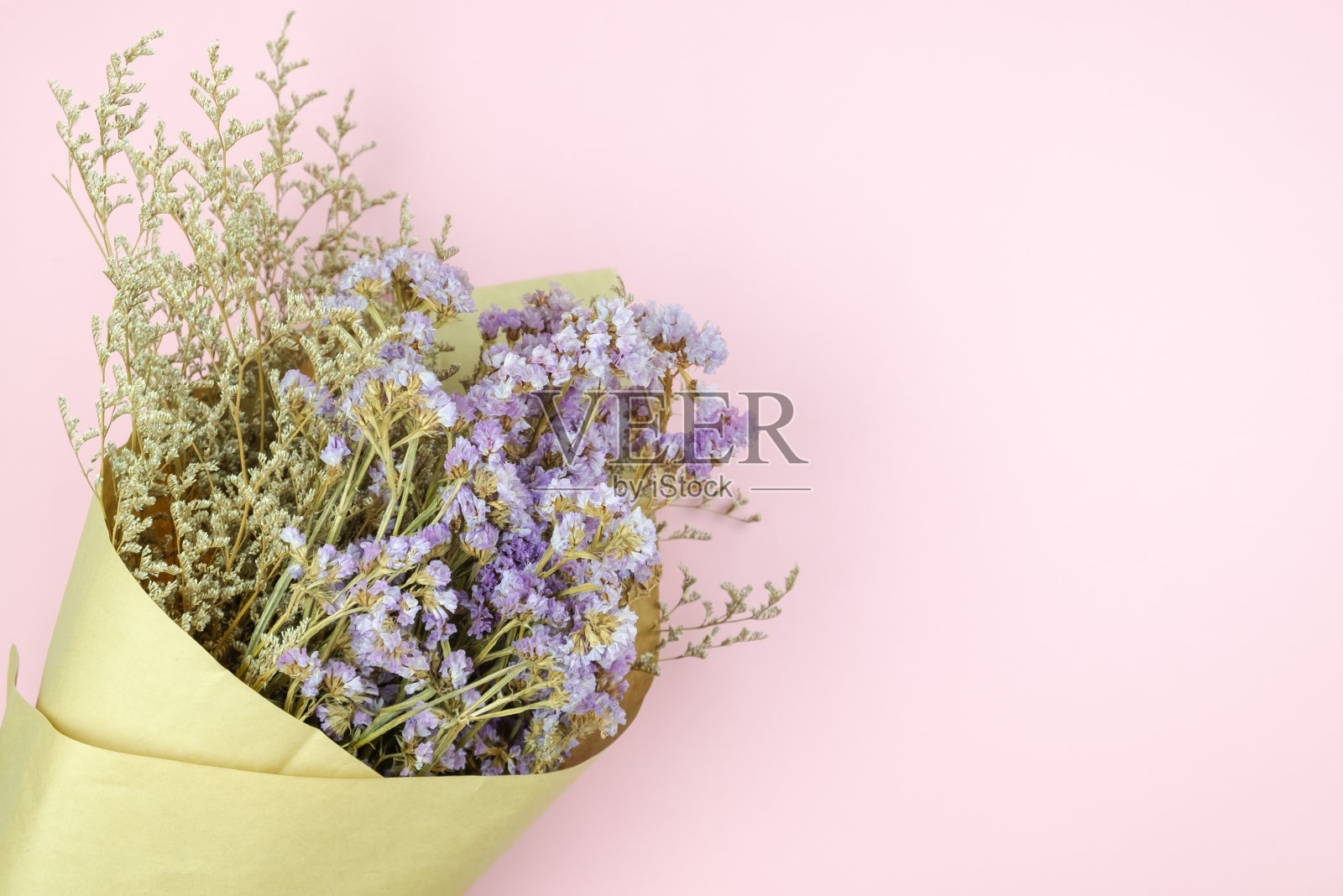 可爱的紫罗兰花和白色的肉桂花束在淡粉色的背景照片摄影图片