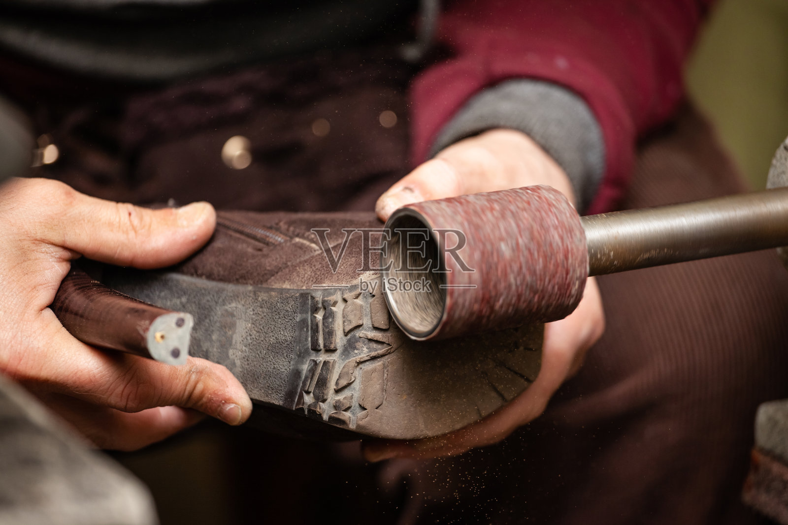 男性鞋匠的手在机床上打磨鞋底的特写照片摄影图片