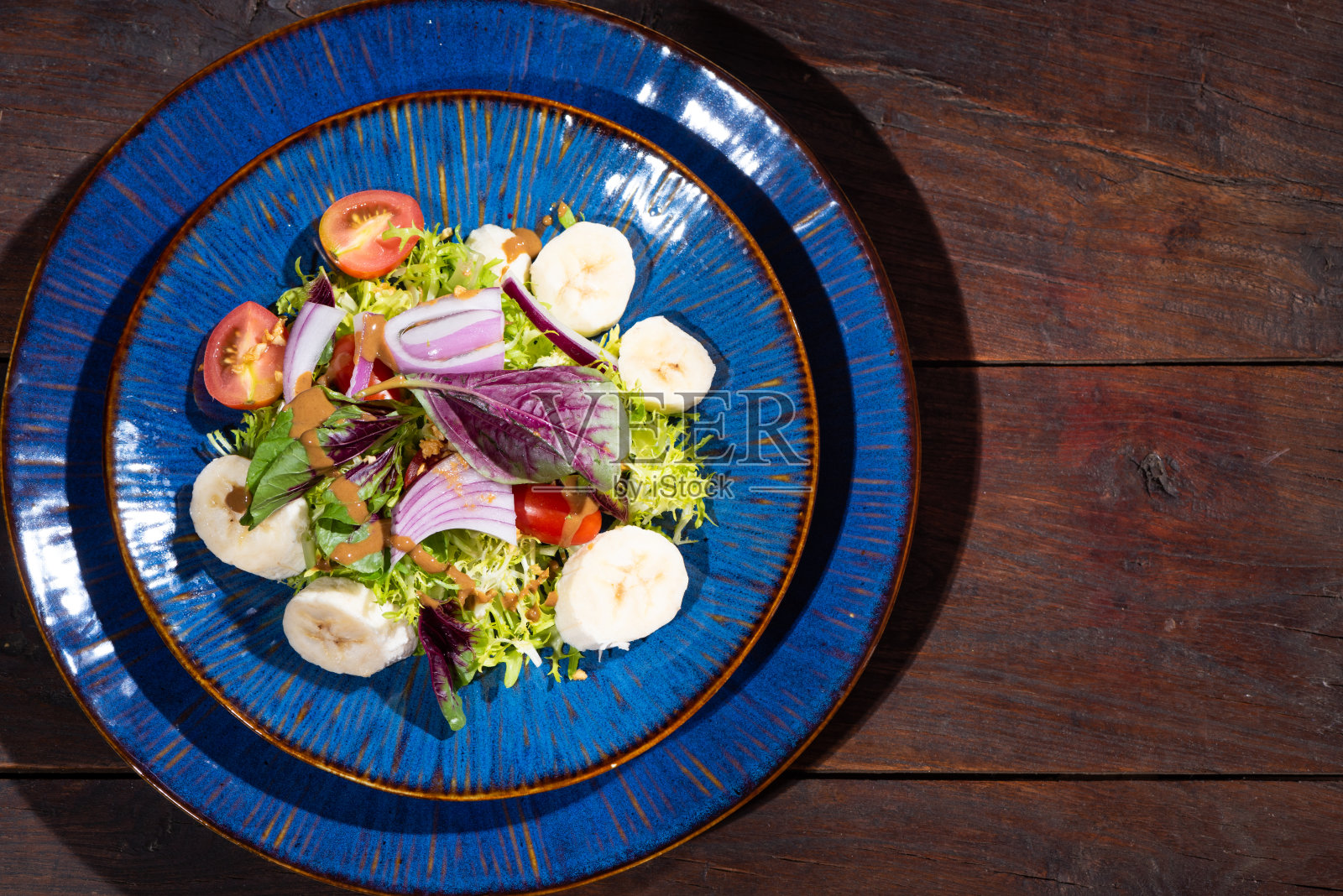 蓝色盘子里的蔬菜和水果沙拉照片摄影图片