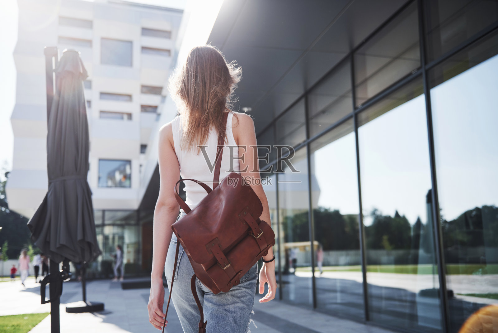 美丽，快乐的年轻学生女孩背着书包在大学校园附近。教育休闲理念照片摄影图片