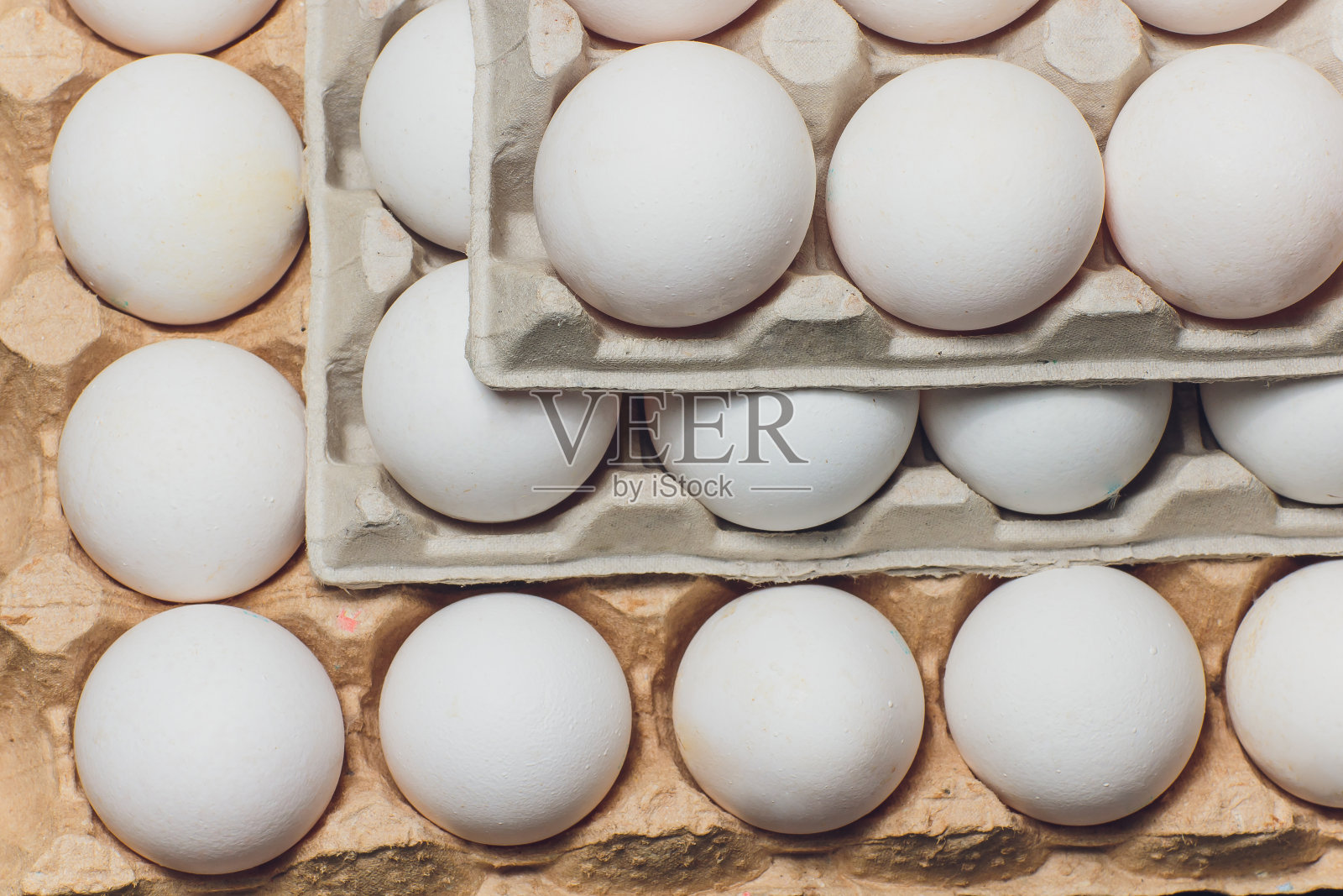 几个白鸡蛋装在一个鸡蛋盒里。照片摄影图片