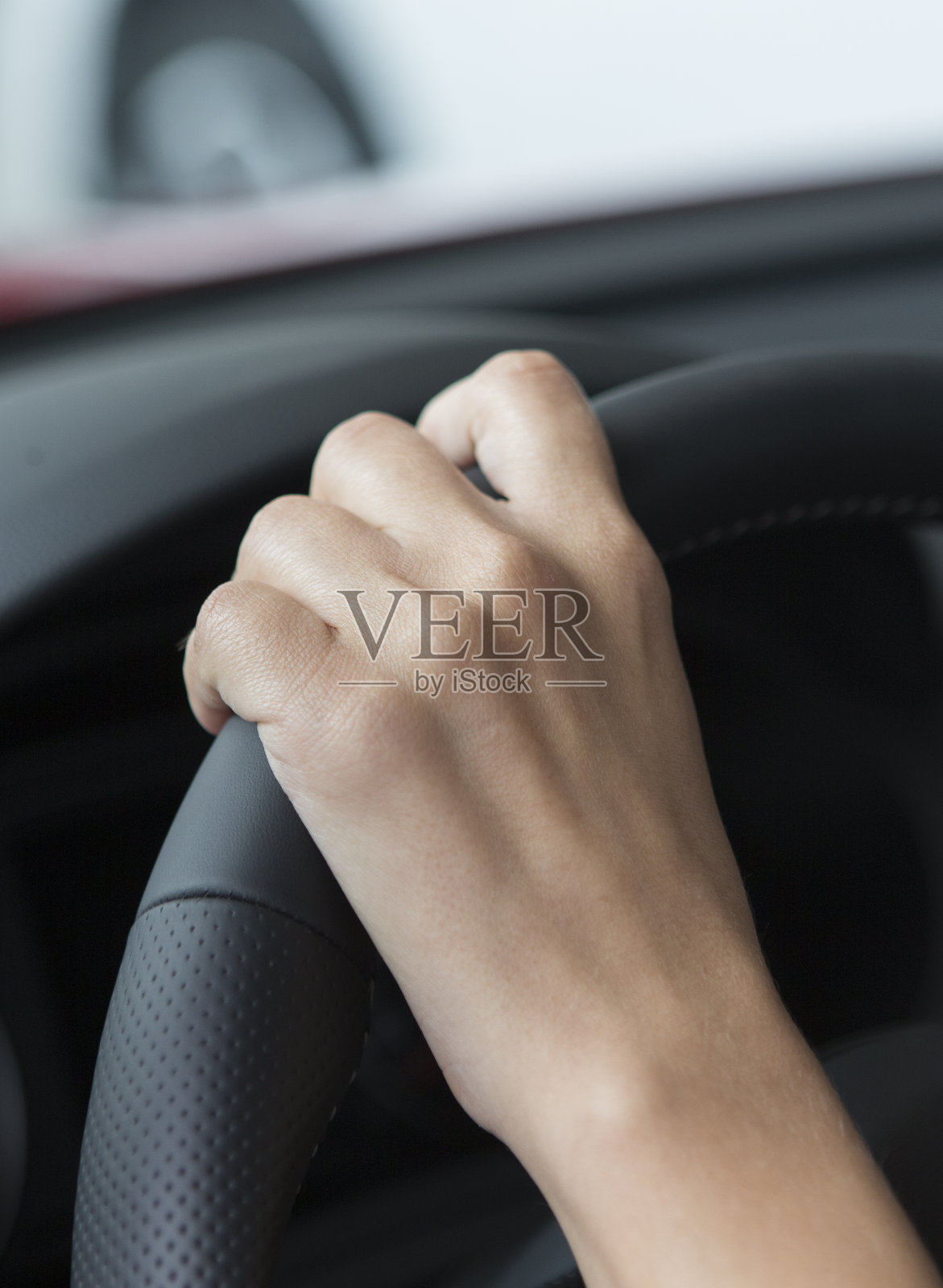 一个修了漂亮指甲的女孩的手放在一辆轿车的把手上。照片摄影图片