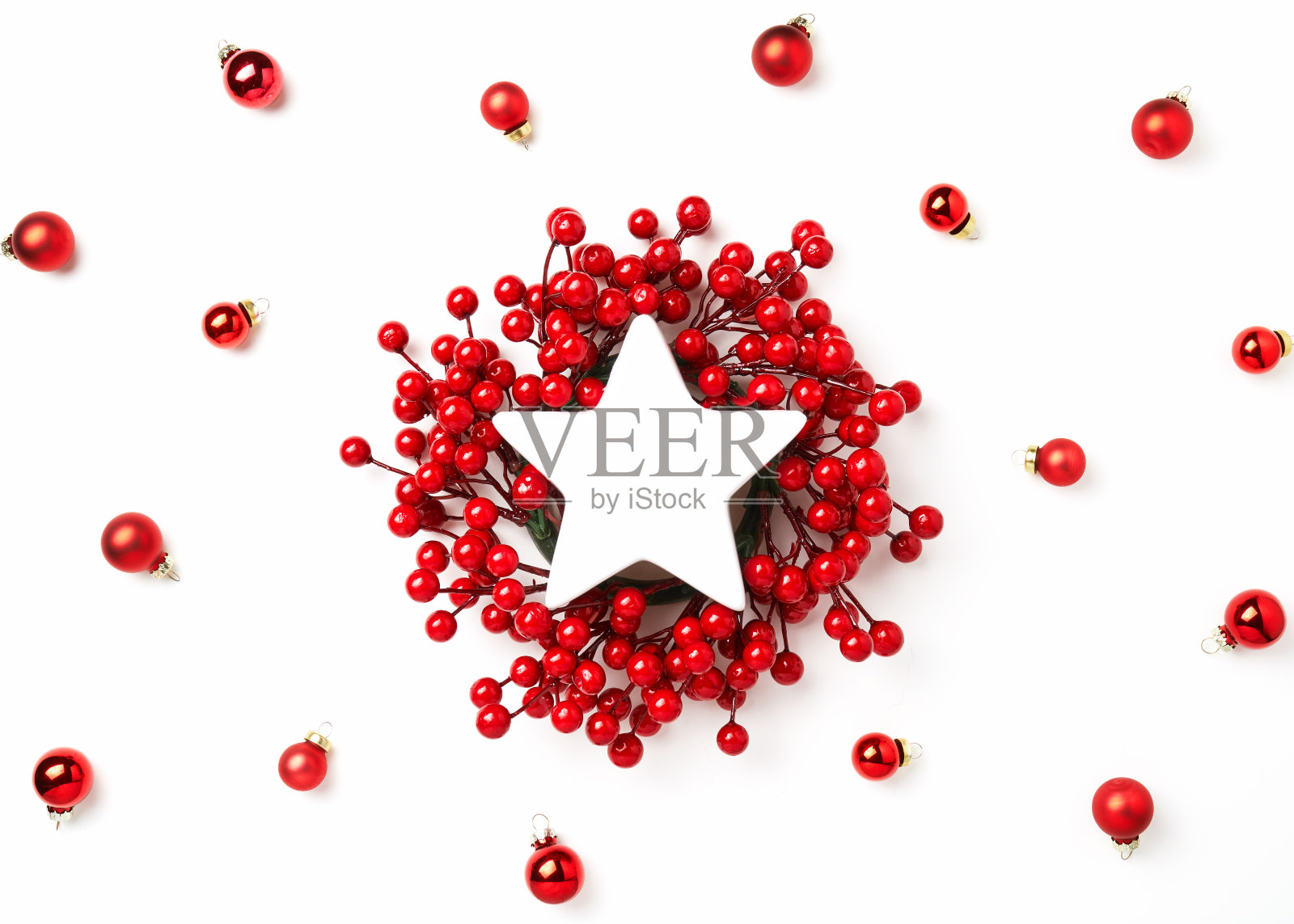 圣诞frame-postcard。圣诞花环的树枝上挂着红色的浆果，中间是一颗白色的星星，在白色的背景上点缀着红色的圆球，是圣诞的装饰品。一个现成的想法为你的文本照片摄影图片