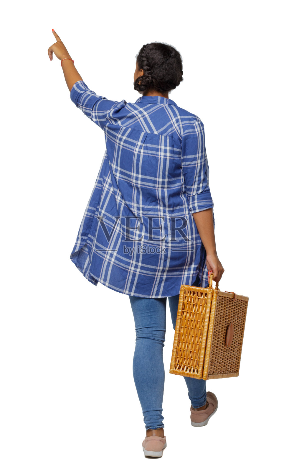 一个年轻的黑人女孩在牛仔裤与野餐袋的后视图。照片摄影图片