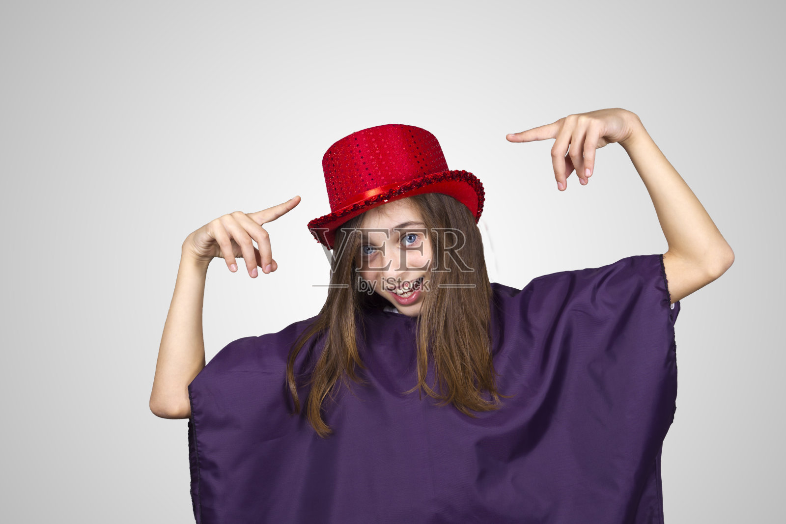 戴着红帽子的狂欢节女孩做着鬼脸照片摄影图片