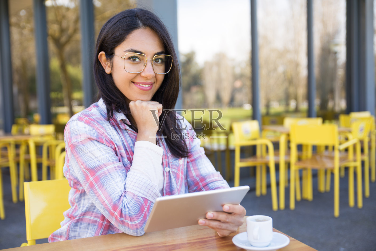 微笑的女人使用平板电脑和喝咖啡在咖啡馆照片摄影图片