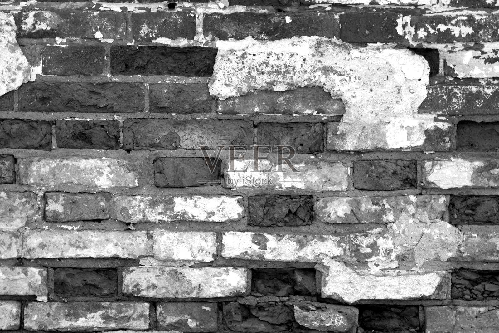 破旧的砖墙表面是黑白相间的。照片摄影图片