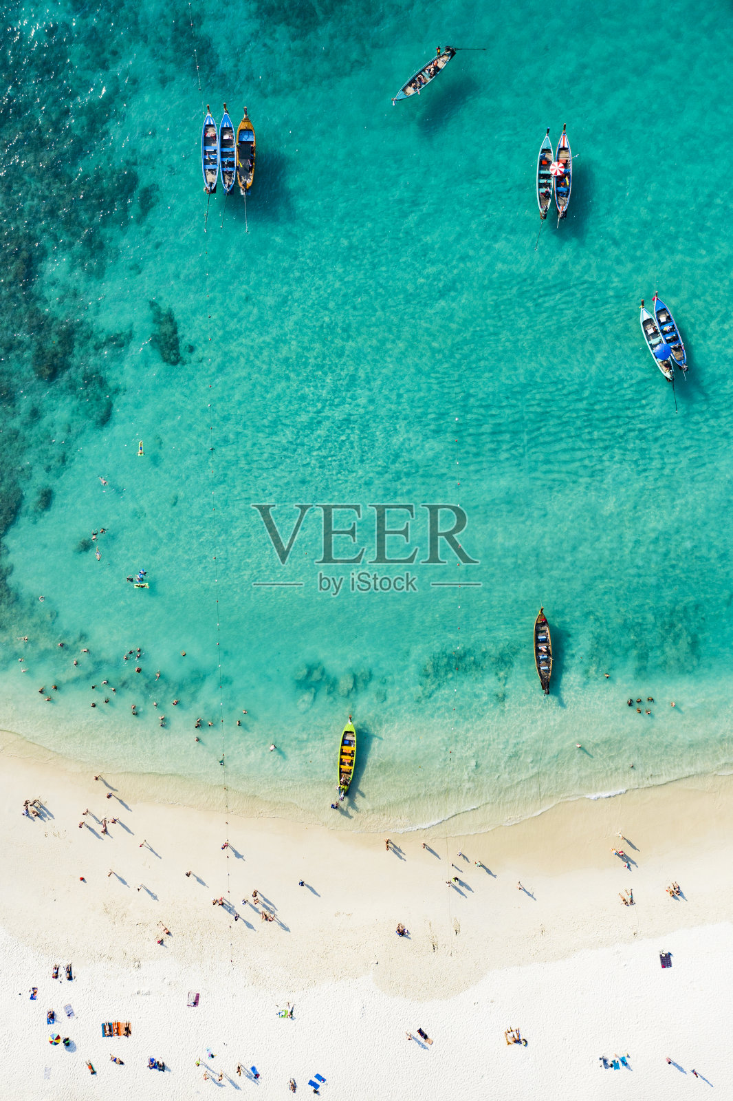 从上面看，鸟瞰美丽的热带海滩，白色的沙子和绿松石般的清澈海水，长尾船和人们日光浴，自由海滩，普吉岛，泰国。照片摄影图片