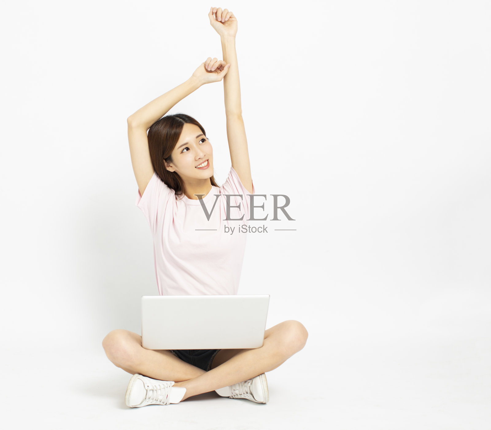 快乐的年轻女子坐在地板上用笔记本电脑照片摄影图片