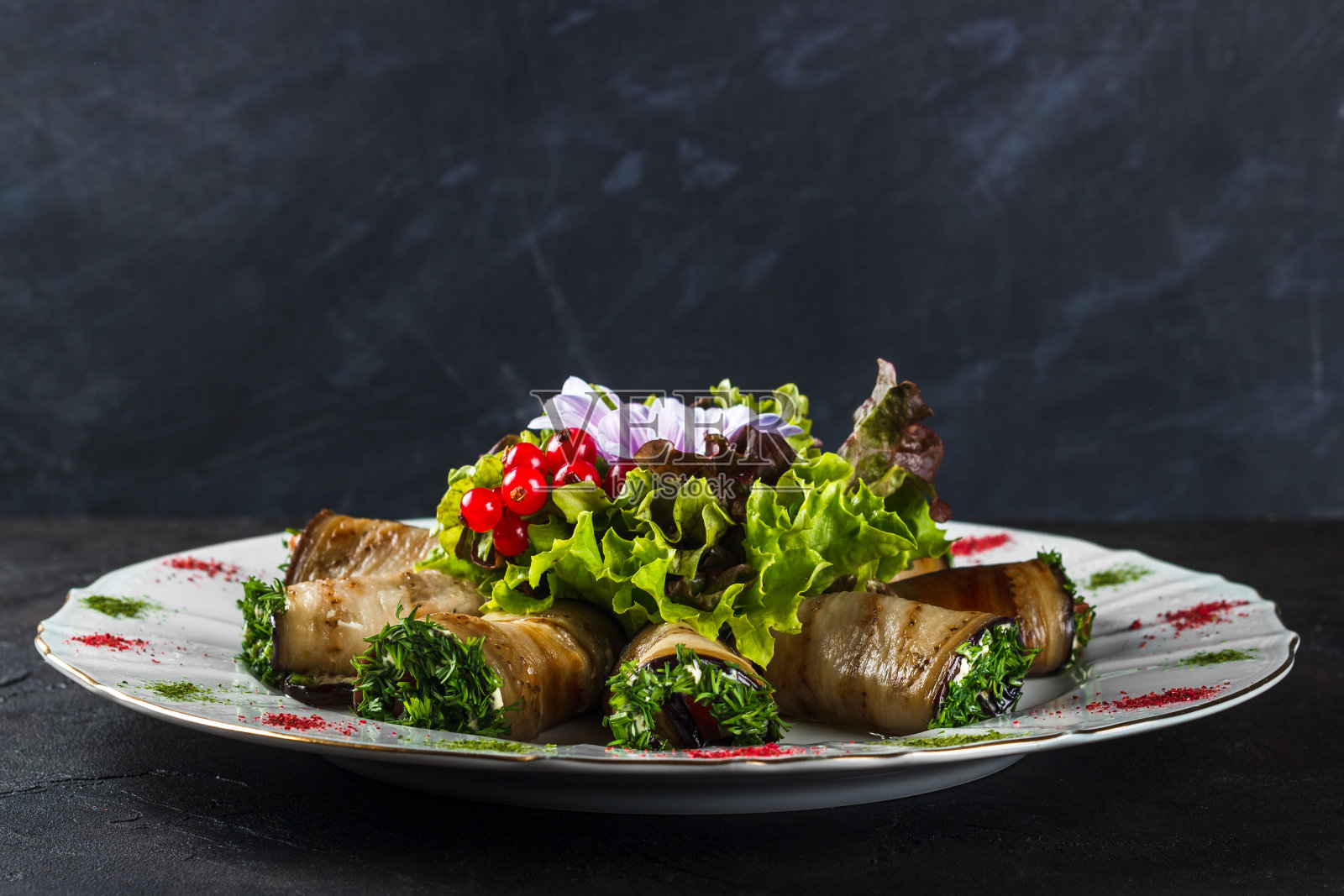 这道开胃菜是茄子配咸鲑鱼，以生菜和花作装饰照片摄影图片