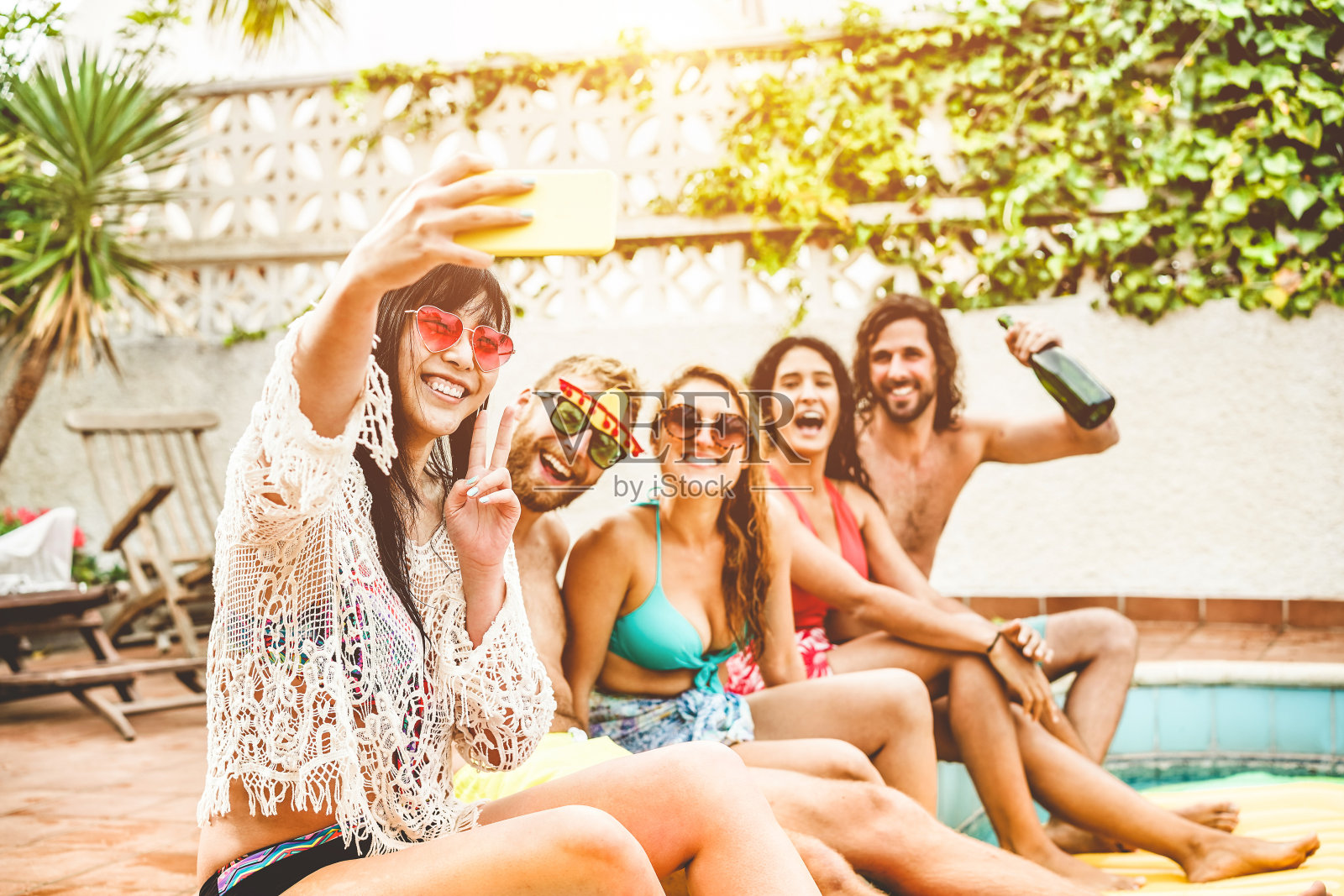 快乐的朋友庆祝拍照自拍在游泳池派对-年轻人有乐趣的暑假-旅游，友谊，青年和科技趋势的概念-聚焦亚洲女孩的脸照片摄影图片