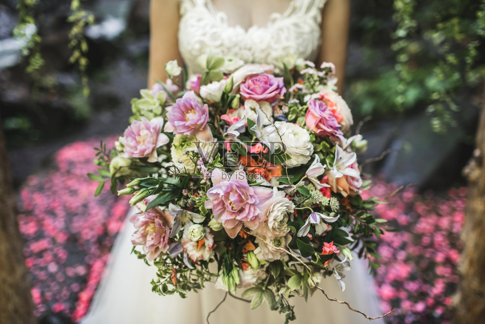 美丽多彩的婚礼花束在新娘的手中。粉红色和珊瑚色的精致颜色。照片摄影图片