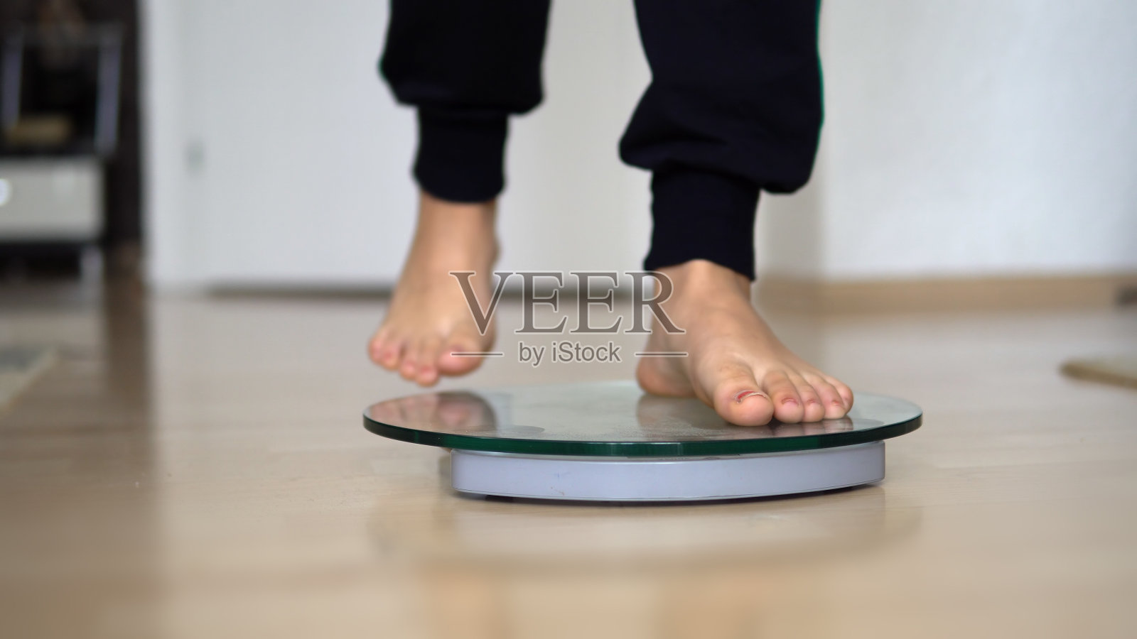 女性光脚配体重秤在木地板上，减肥节食照片摄影图片