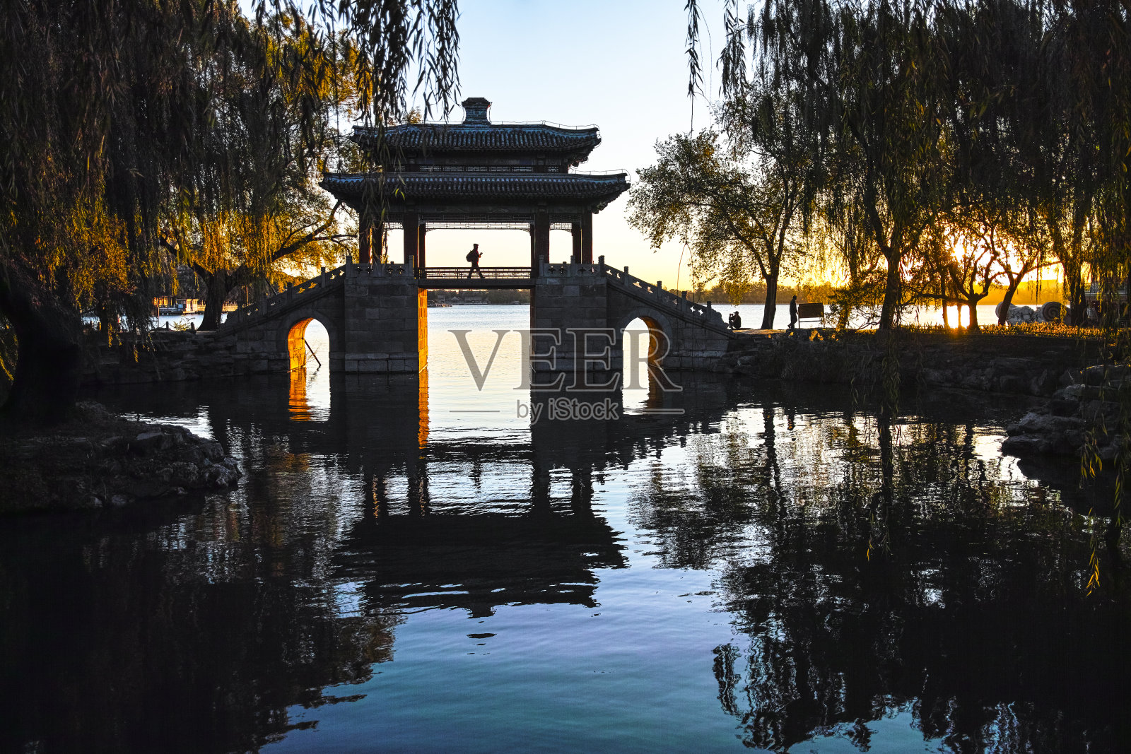 清晨，一名游客从颐和园的一座桥上走过照片摄影图片