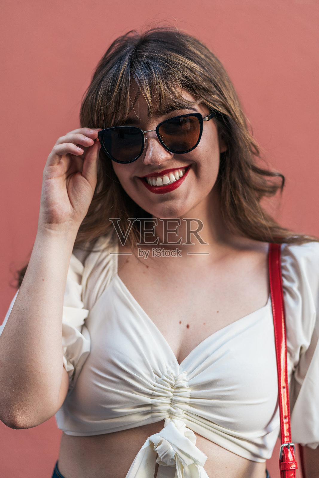 戴着时髦太阳镜，面带微笑的女人照片摄影图片