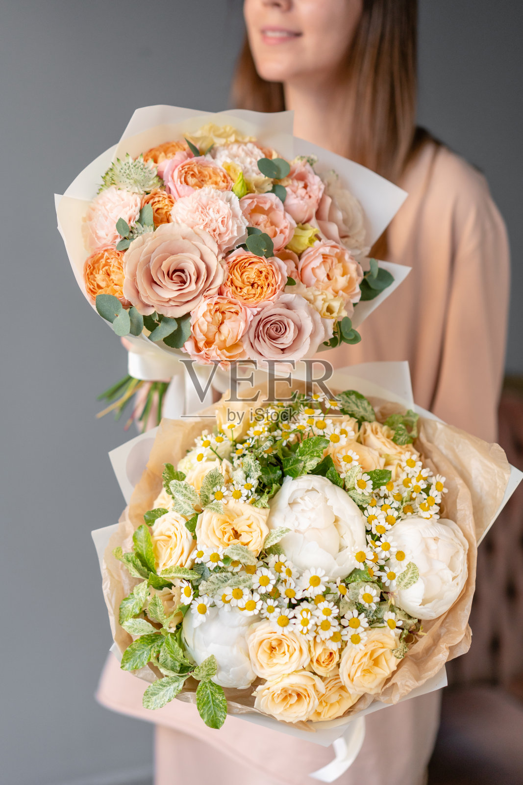 女人手里拿着两束美丽的混合鲜花。花卉商店的概念。鲜花交付照片摄影图片