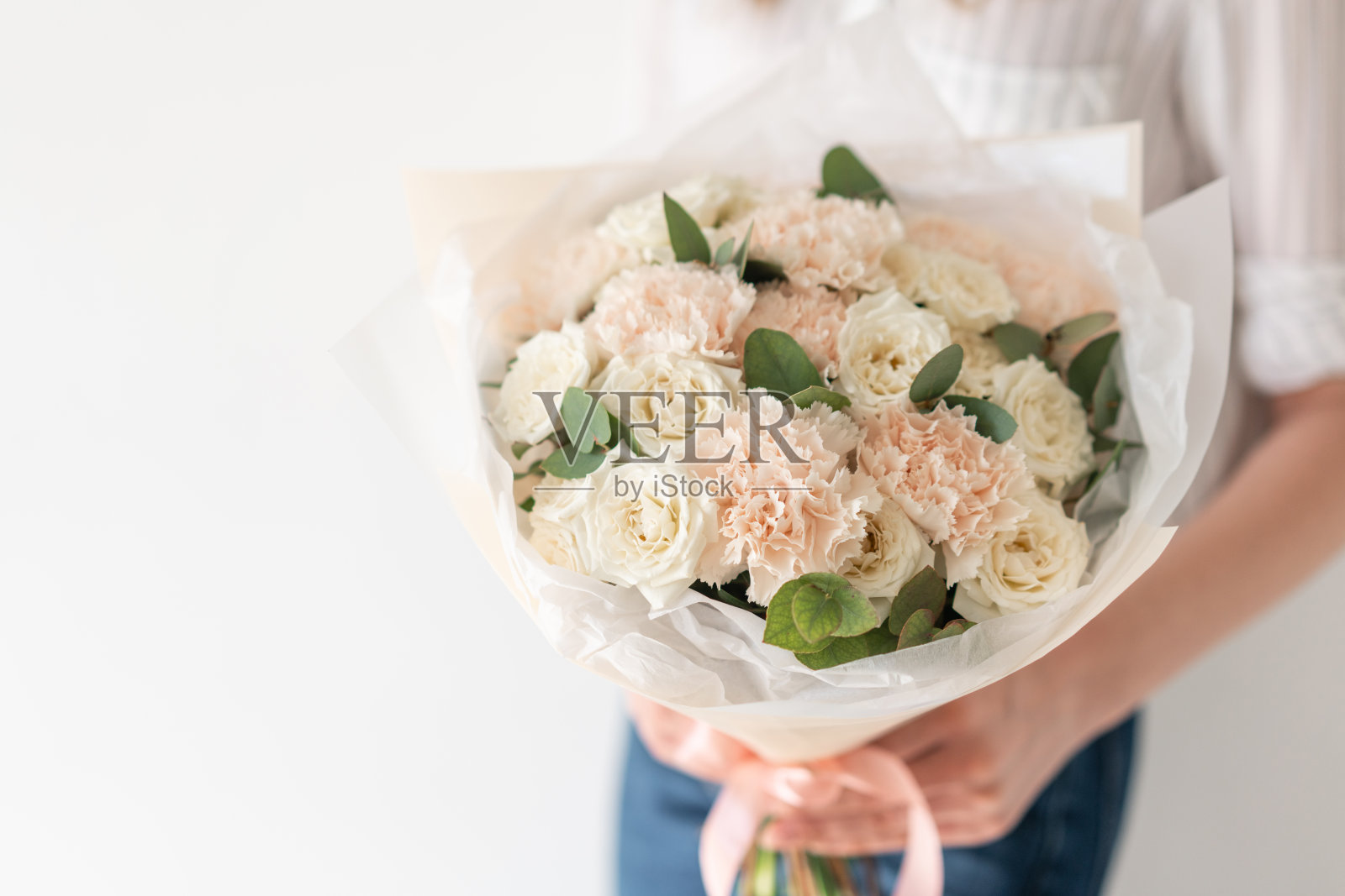 女子手中精致的混合鲜花。花店花匠的工作。精致柔和的颜色。新鲜切花。白色和粉红色照片摄影图片