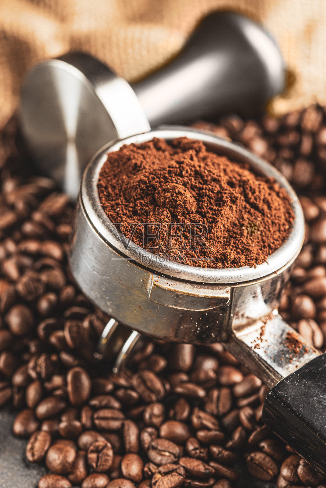 咖啡捣固机，咖啡压榨机是由不锈钢和烘培咖啡豆从咖啡烘培机在黑色背景，工具捣固照片摄影图片