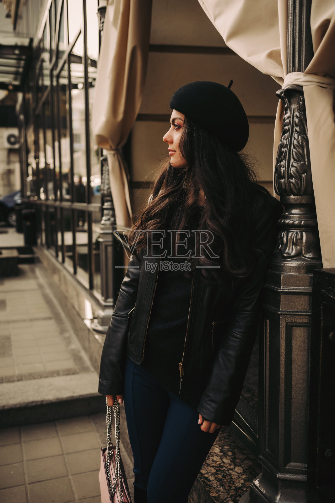 一个黑发女人在城市里走来走去。照片摄影图片