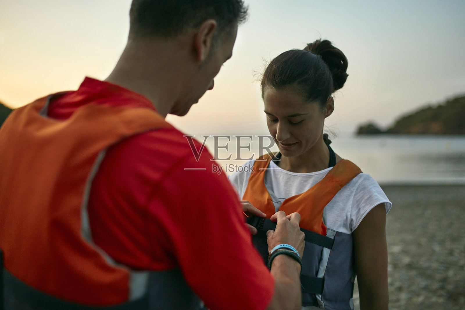 皮划艇运动员帮助朋友穿上救生衣划桨旅行照片摄影图片