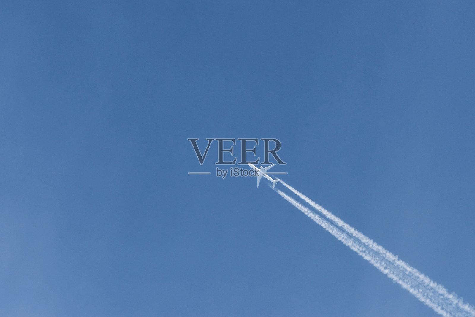 在晴朗的日子里，现代飞机在蓝天上翱翔。速度和能量照片摄影图片