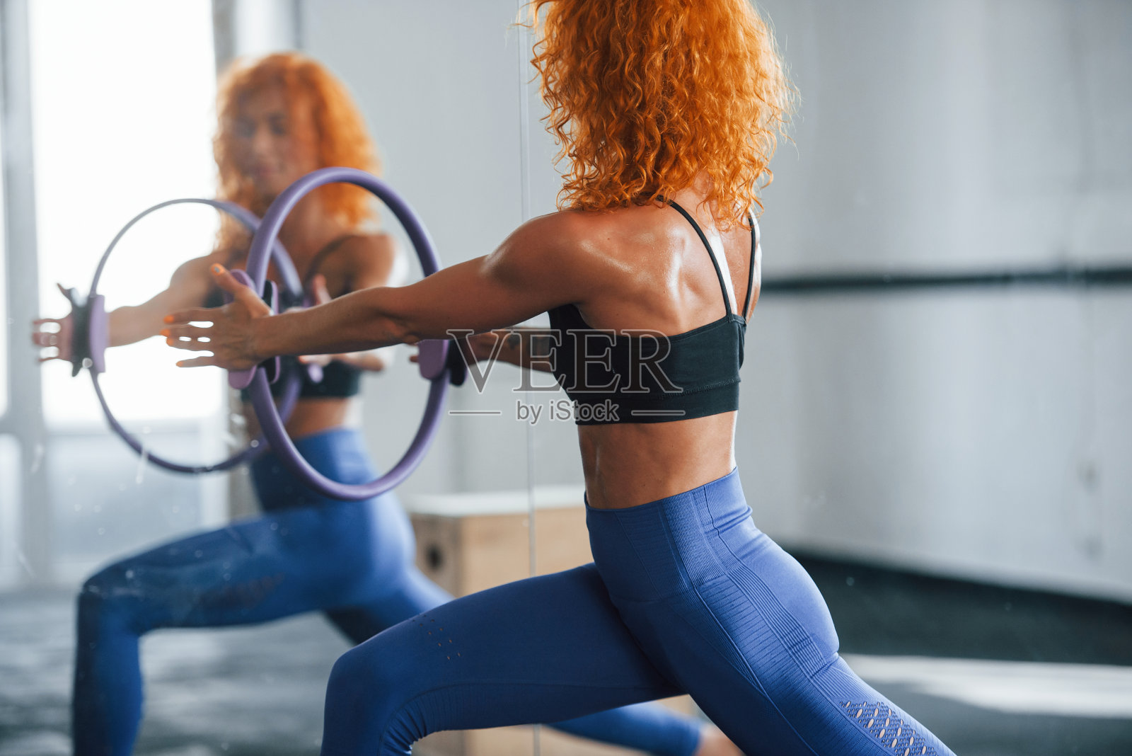 有特殊设备。喜欢运动的红发女孩白天去健身房健身。肌肉发达的身体类型照片摄影图片