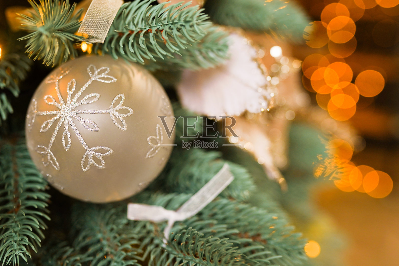 圣诞树上挂着金球，飘着雪花。新年主题快乐照片摄影图片
