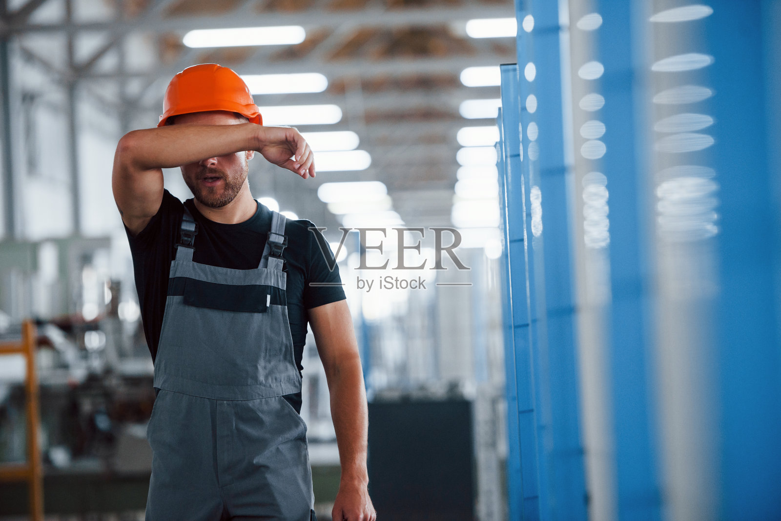 脱下安全帽。后的工作。工厂内的工业工人。年轻的技术员照片摄影图片