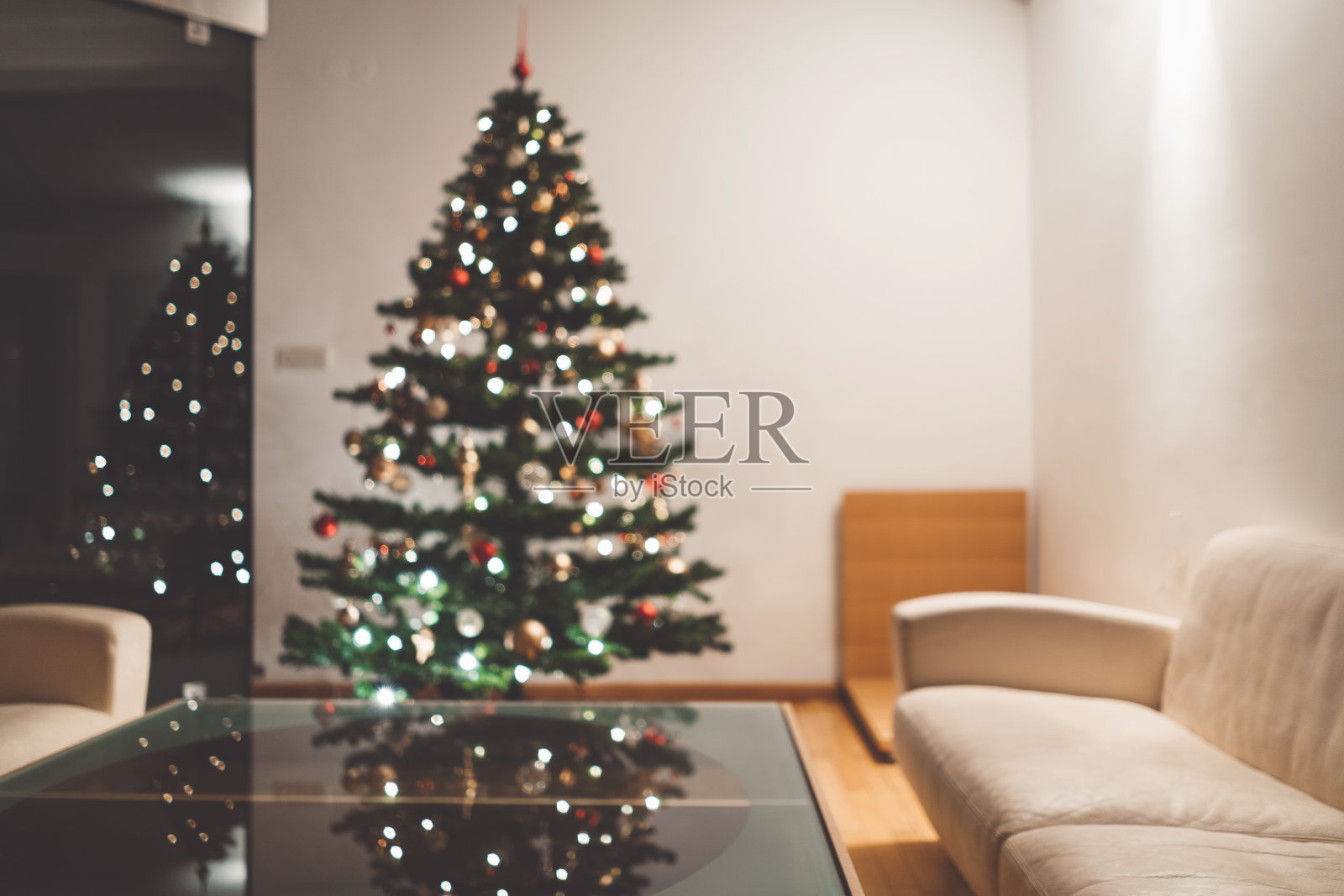 客厅里的一棵没有焦点的圣诞树上有闪亮的灯光照片摄影图片