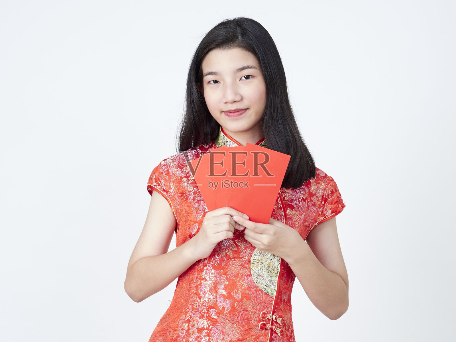 2020年中国新年。身着中国传统旗袍的年轻女子手持白色背景上的红包照片摄影图片