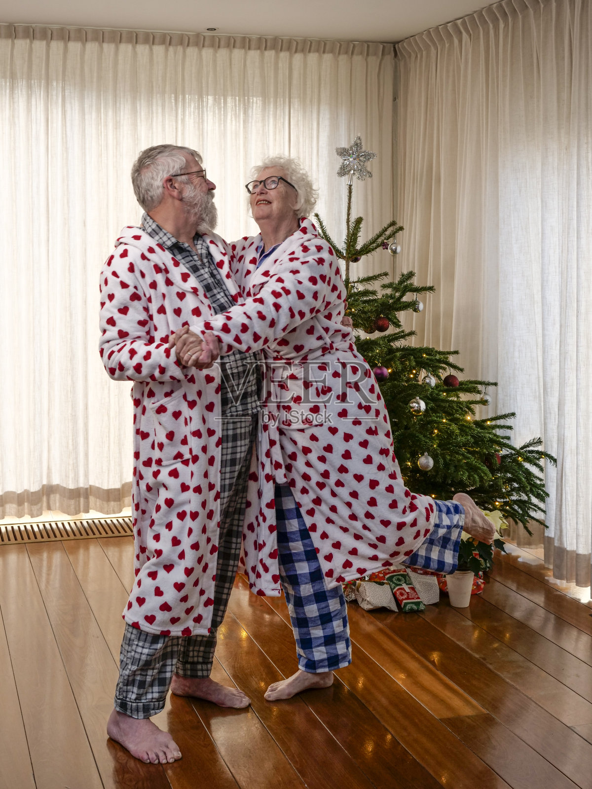 相爱的高年级情侣在圣诞树前跳舞照片摄影图片