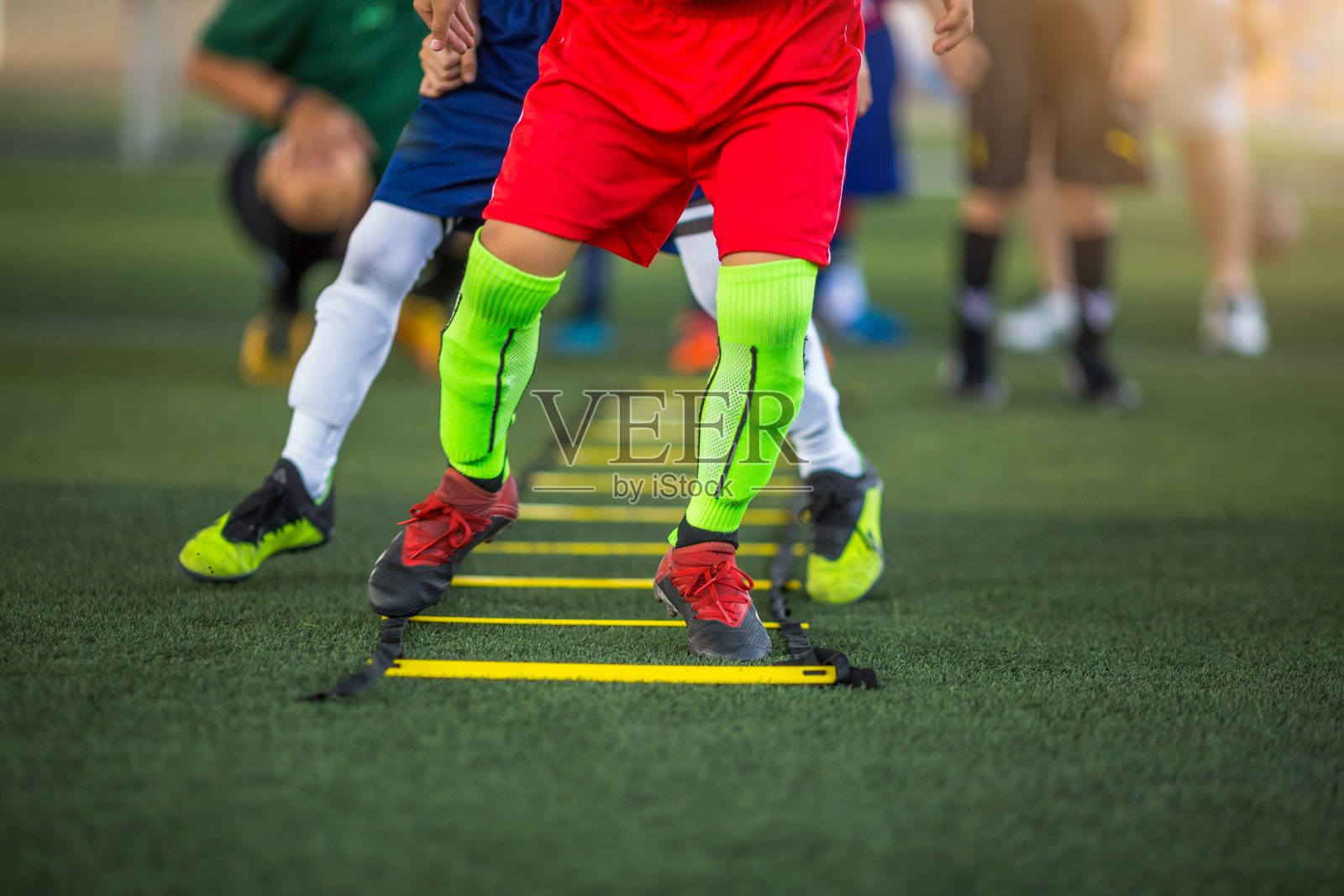 孩子足球运动员在跑步和跳跃的标记之间进行足球训练。照片摄影图片