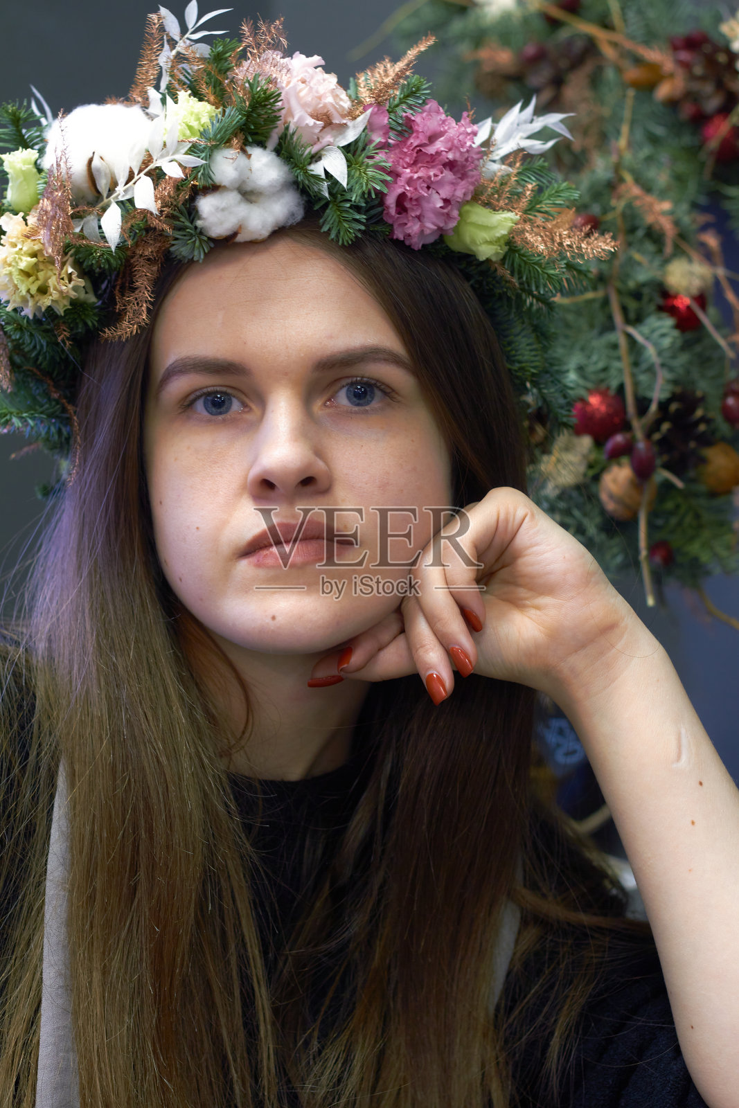 一个美丽的女孩的肖像与黑色的头发在圣诞花环，选择性的焦点照片摄影图片