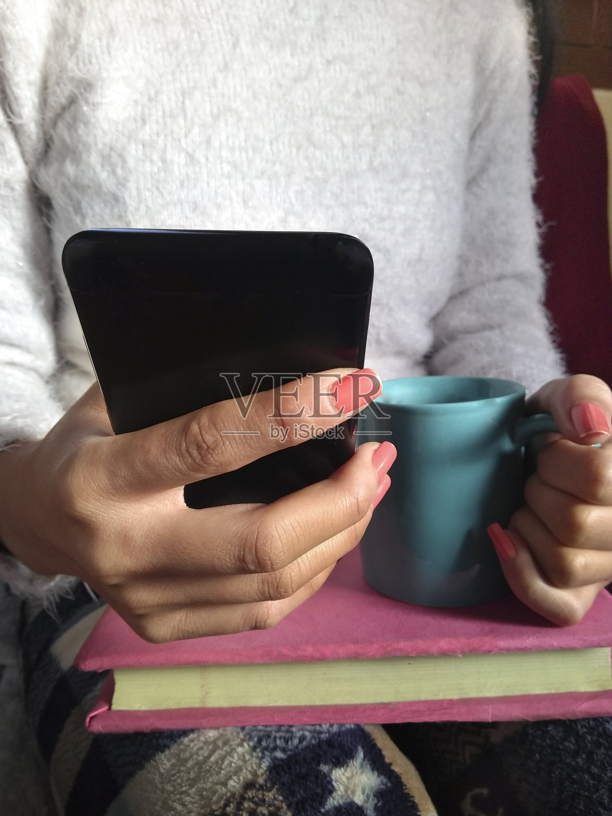 女人一边喝咖啡一边玩手机。照片摄影图片
