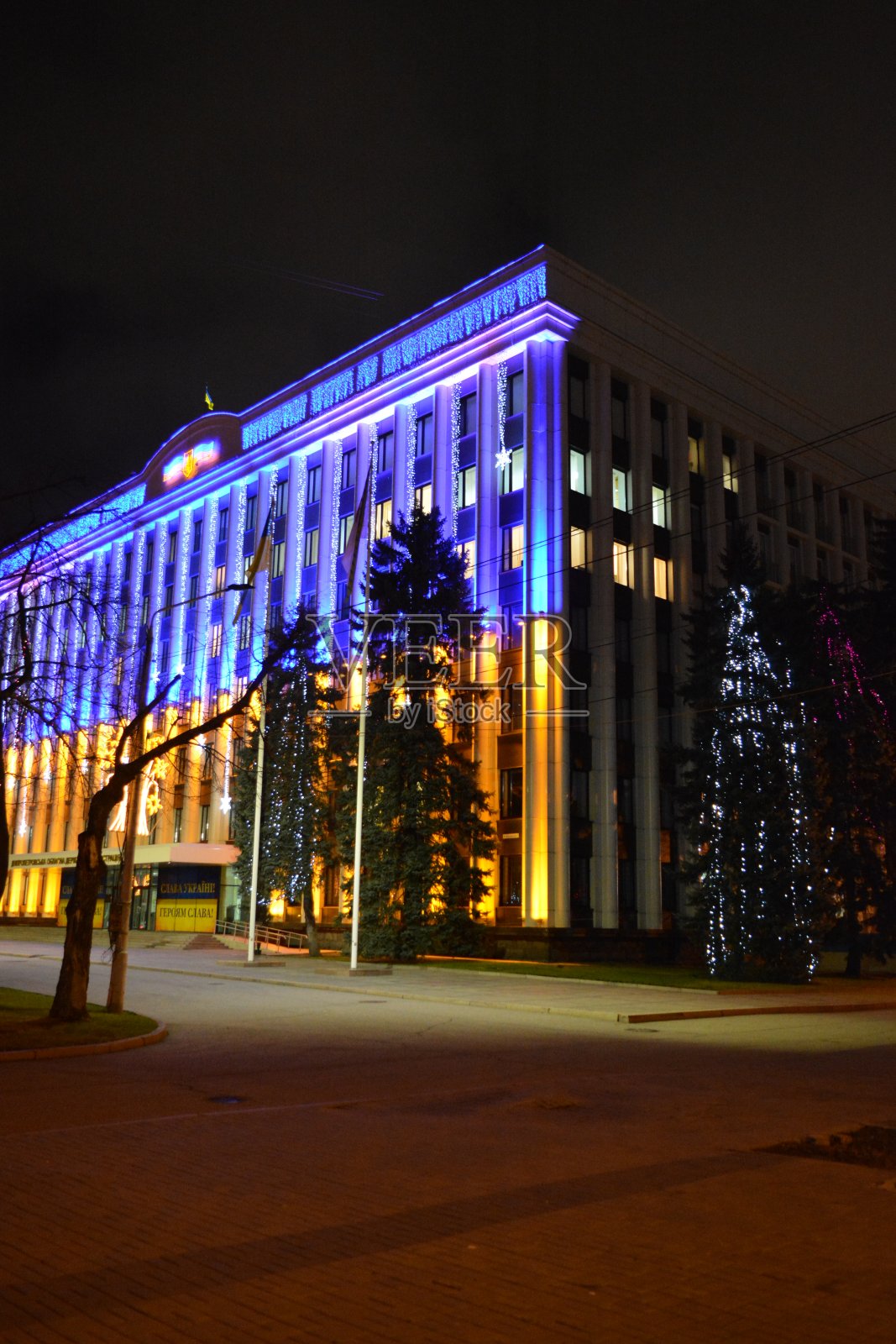 Dnipro地区议会明亮的黄蓝色建筑，装饰着新年和圣诞节的花环。照片摄影图片