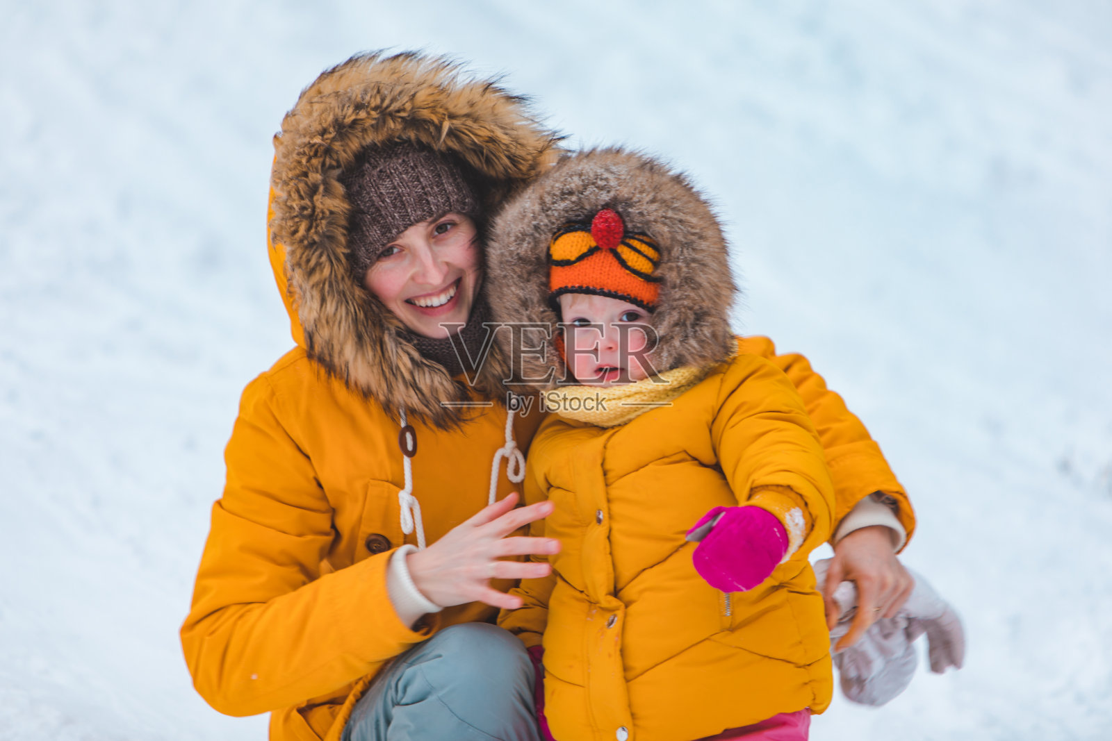 母亲和女儿从冬季山上滑下来照片摄影图片