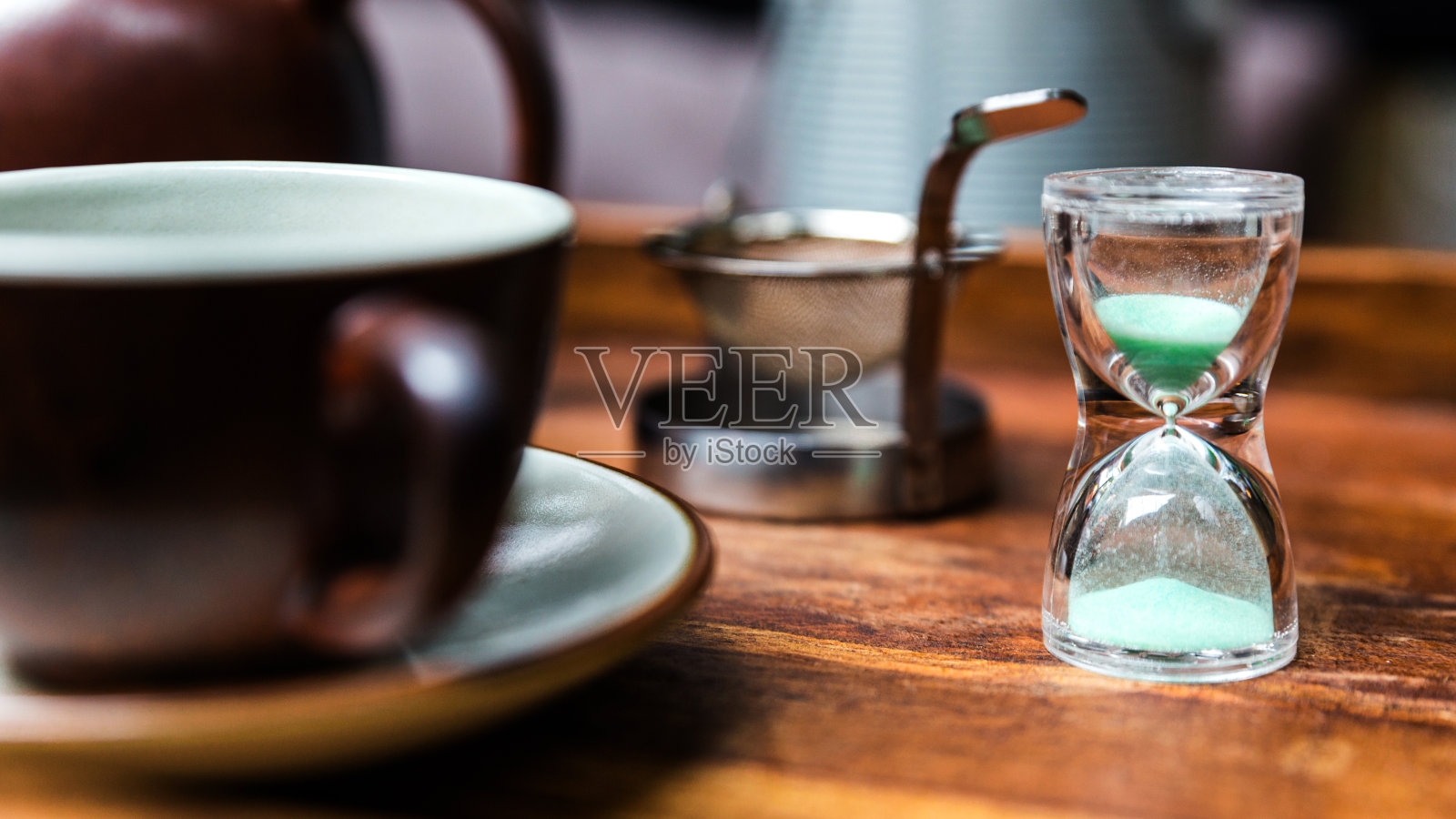小沙钟，制作干花的设备，用不锈钢滤茶器泡茶和一个瓷器古董杯。照片摄影图片