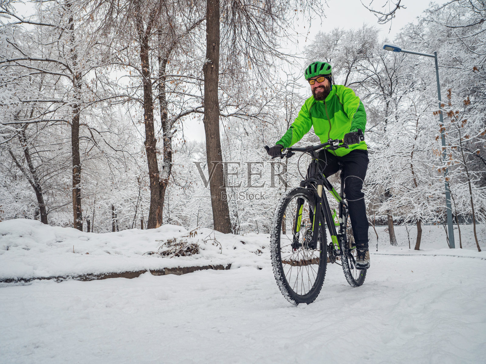 一个人在冬天的公园里骑自行车照片摄影图片