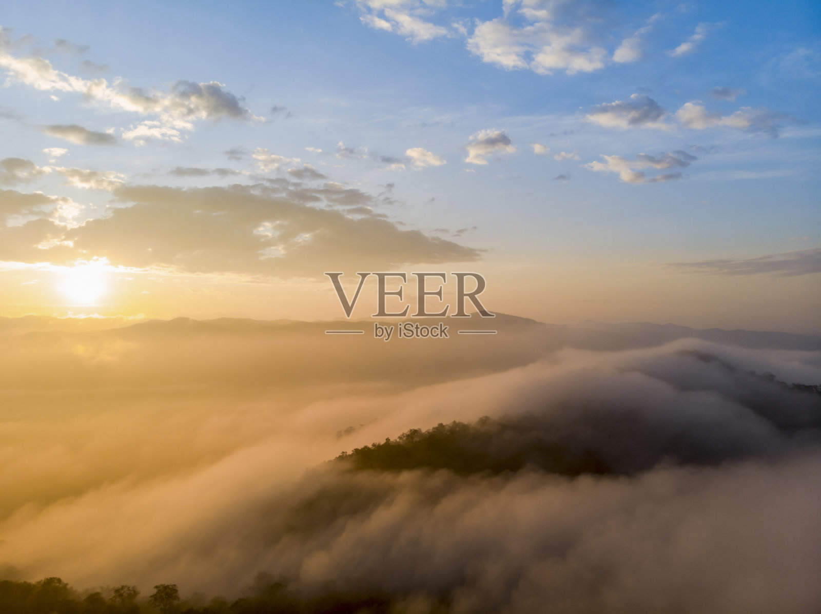 鸟瞰森林中的晨雾薄雾，呼吸群山，阳光洒在晨雾上。照片摄影图片