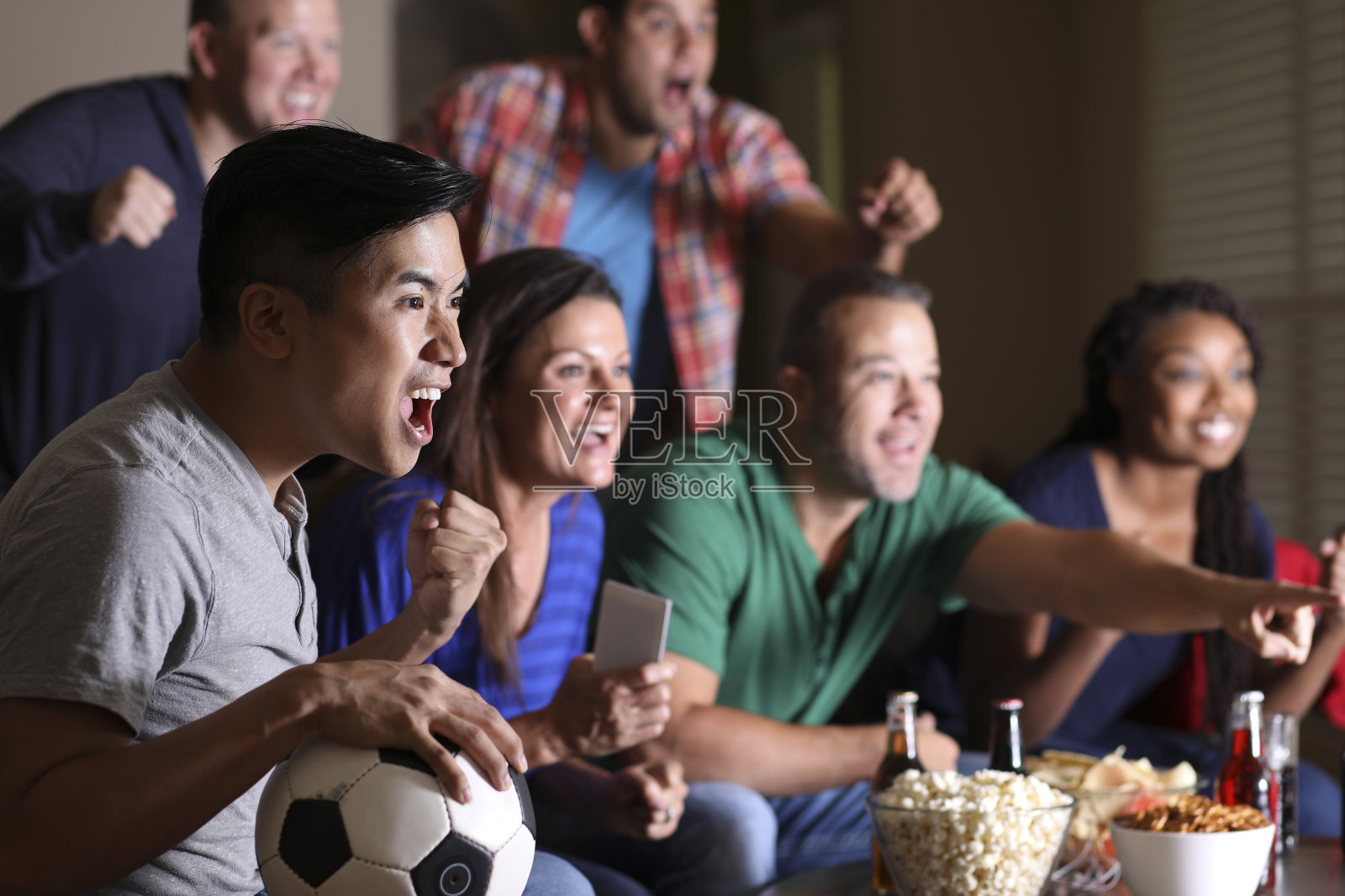 足球迷在家里通过电视观看比赛。照片摄影图片