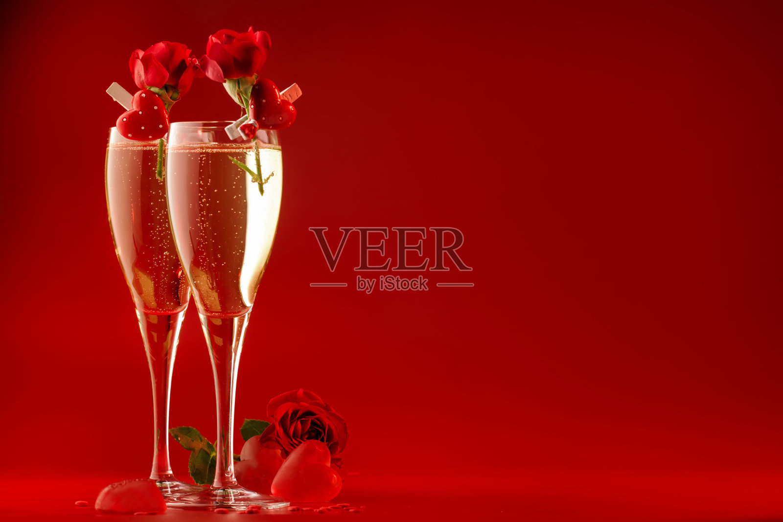 情人节红色背景配香槟酒杯，心形和猩红色玫瑰，复制空间照片摄影图片