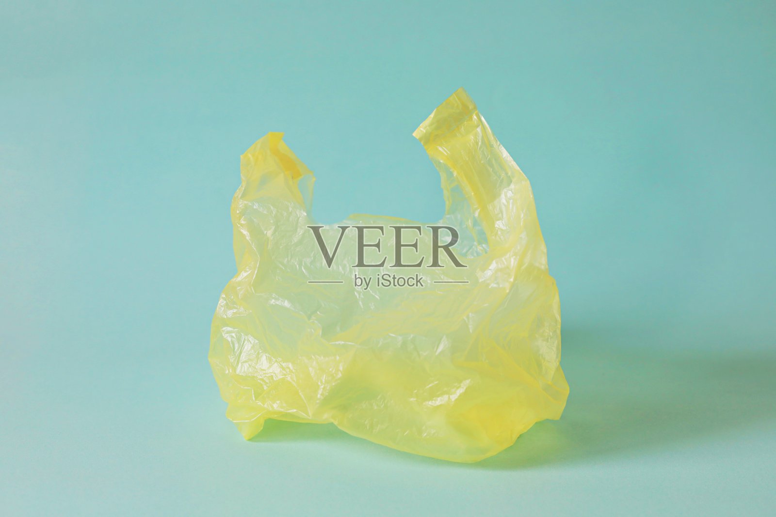 空的黄色塑胶袋与浅蓝色背景的废物回收概念照片摄影图片
