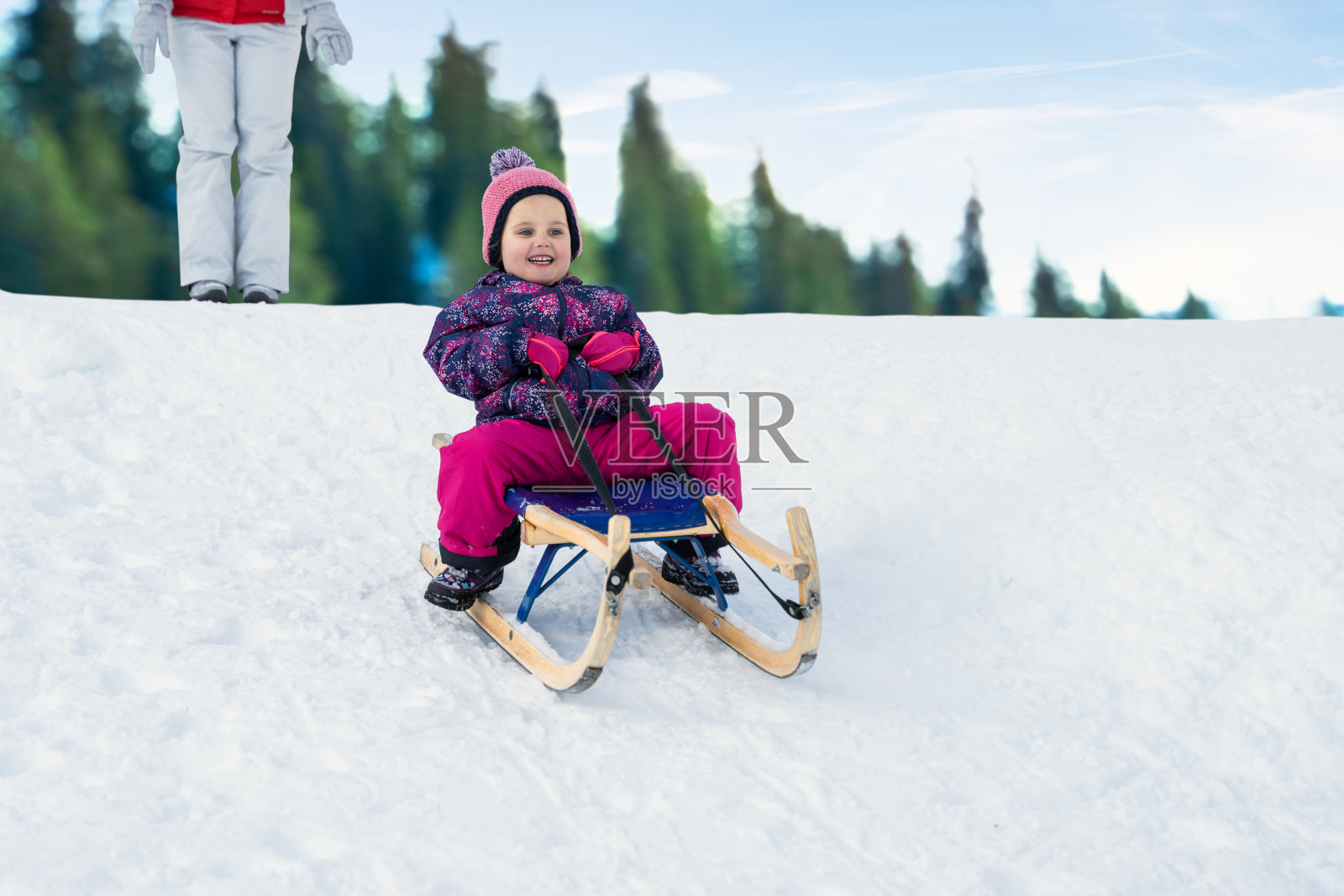 在雪地里玩雪橇的孩子照片摄影图片