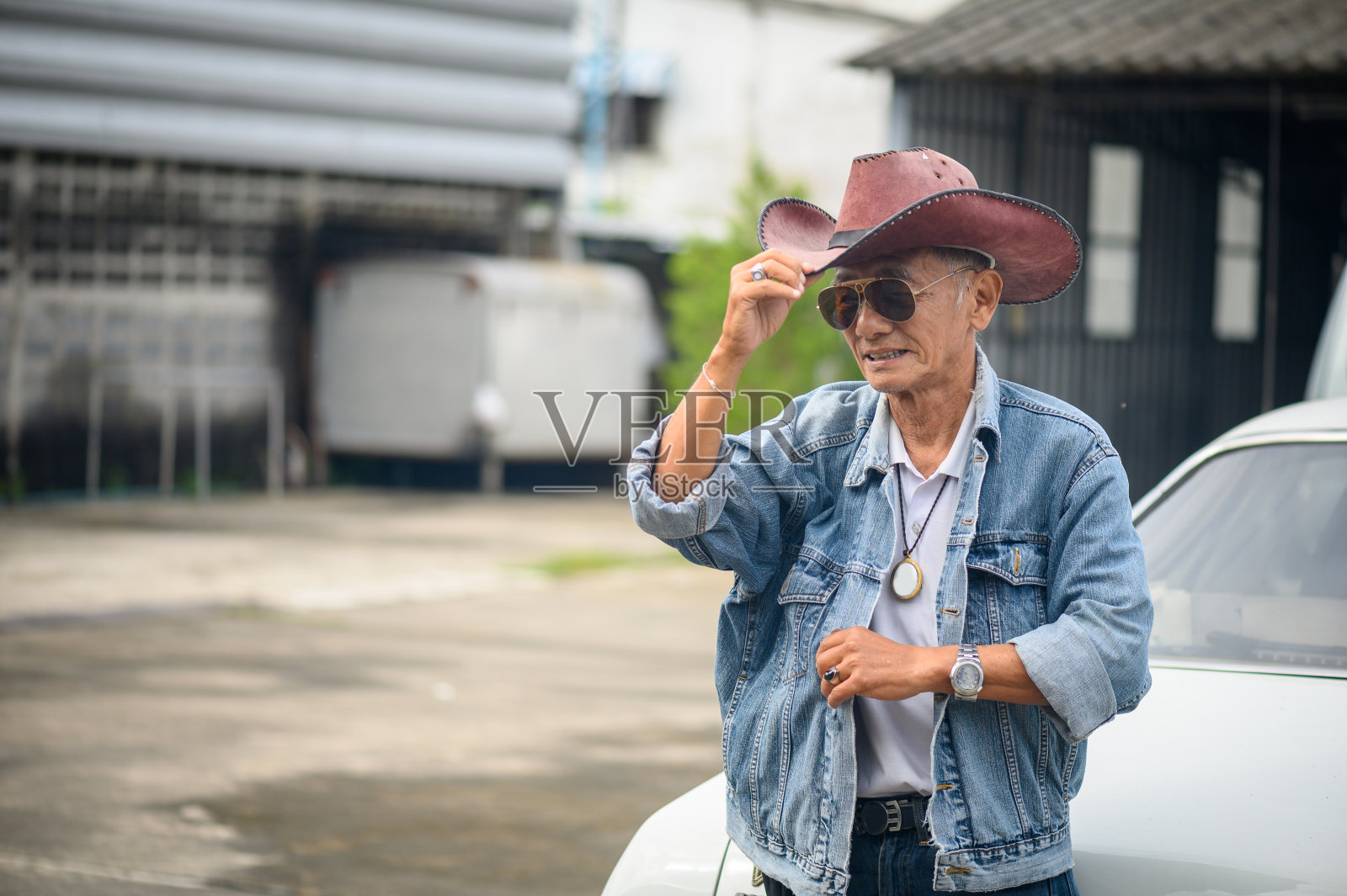年长的亚洲男人的特写戴着棕色的宽边绒面革灌木帽照片摄影图片
