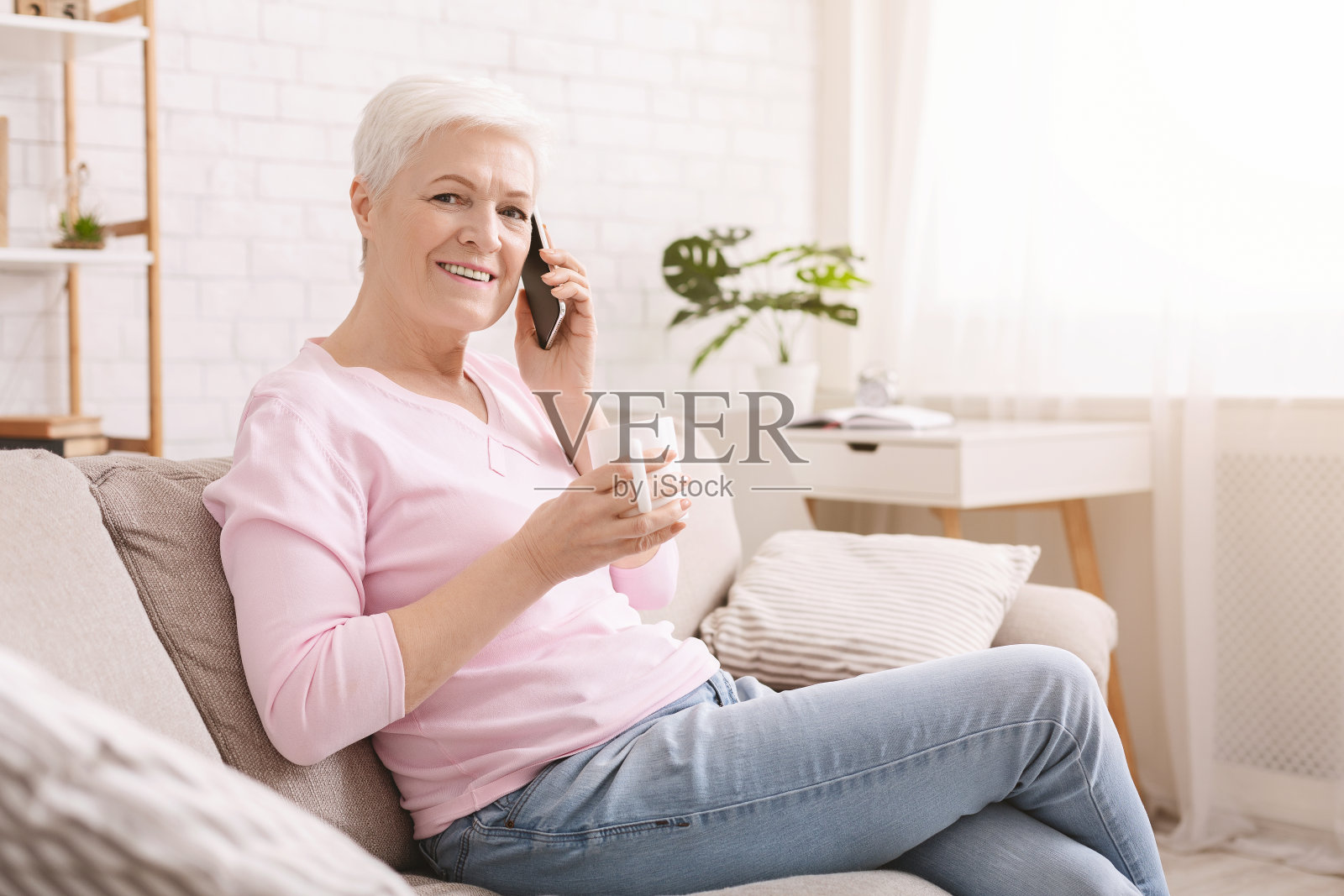 愉快的老妇人在家里享受电话聊天照片摄影图片