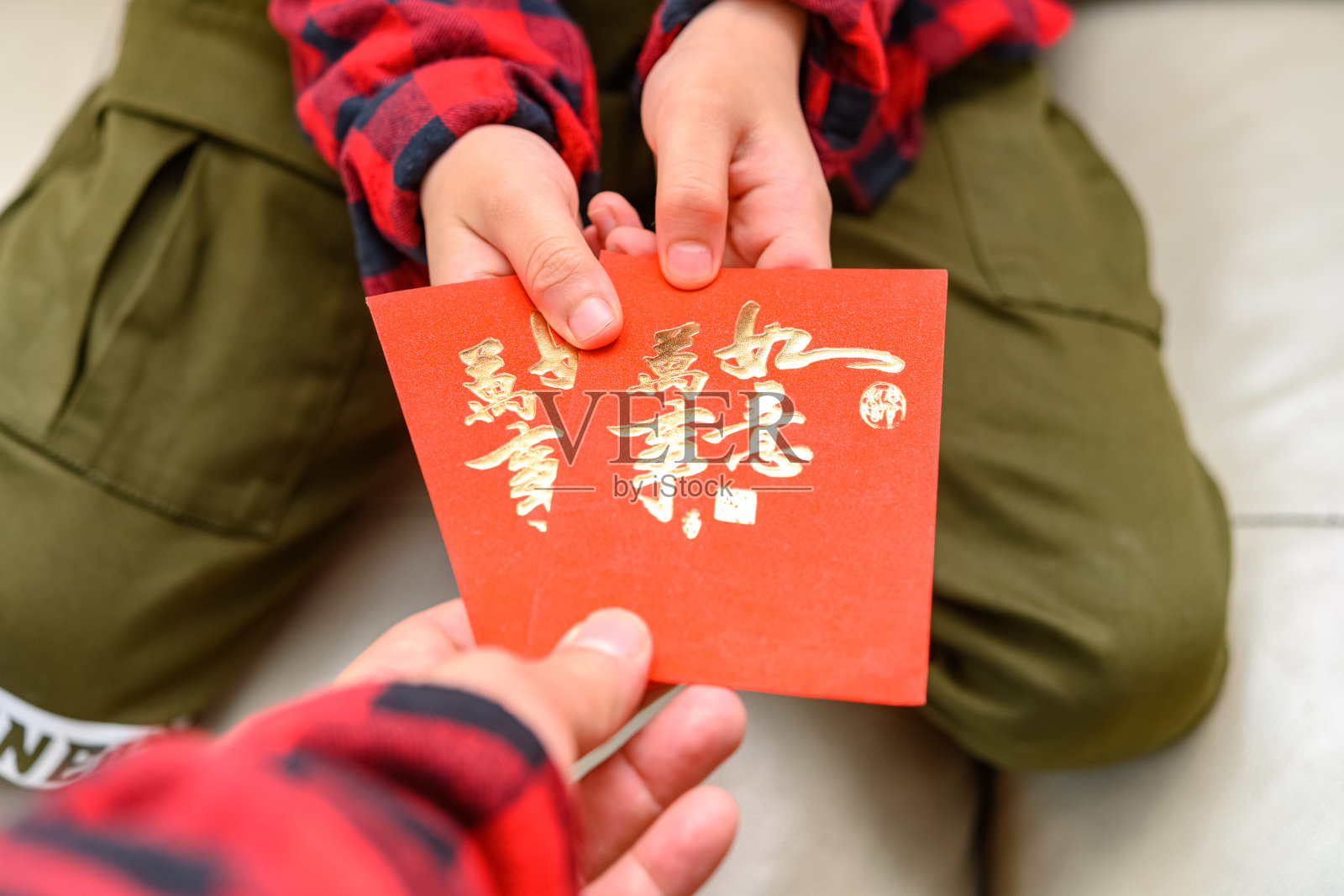 父亲给儿子红色口袋翻译的汉字是一切如愿照片摄影图片