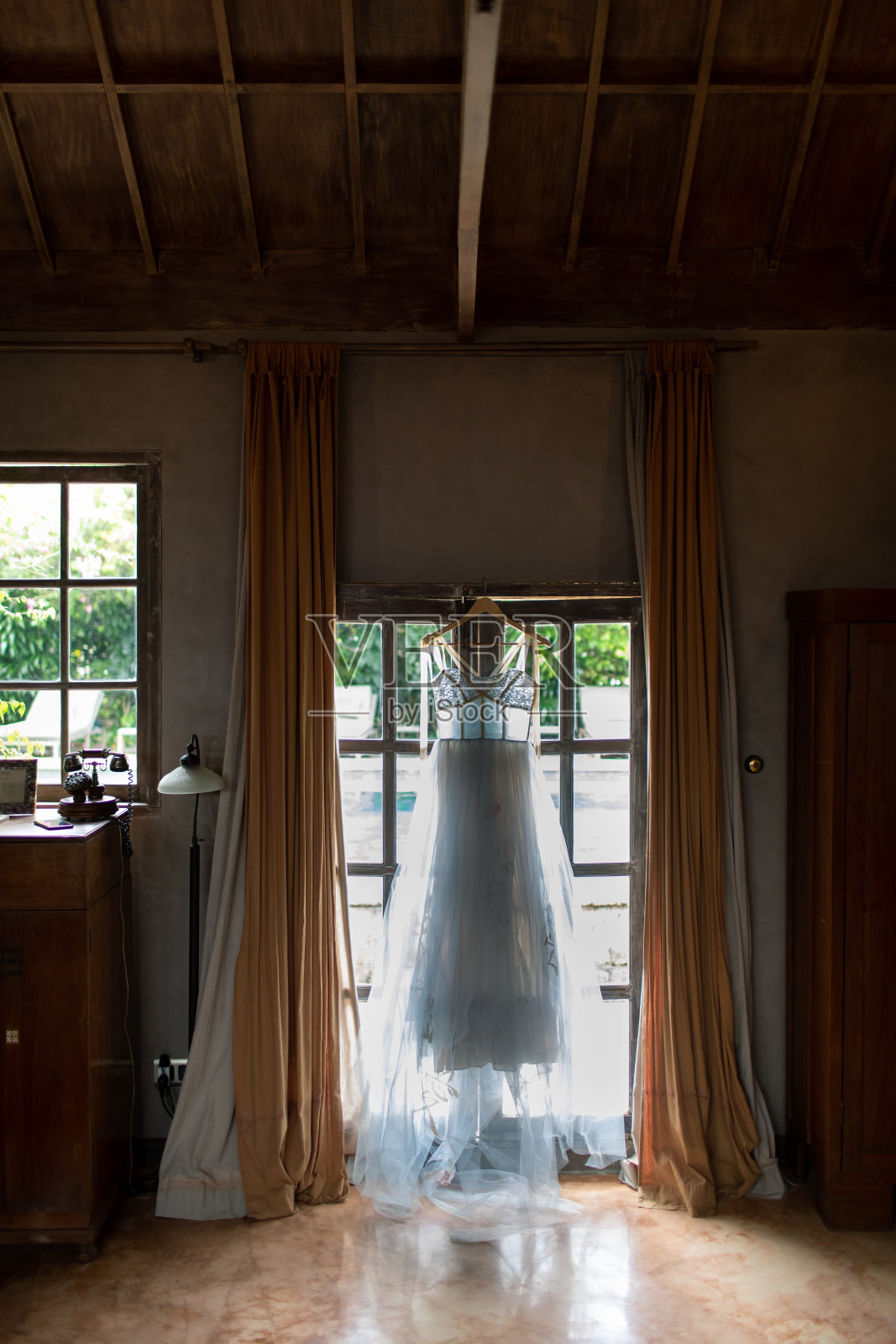婚纱正挂在门上。照片摄影图片