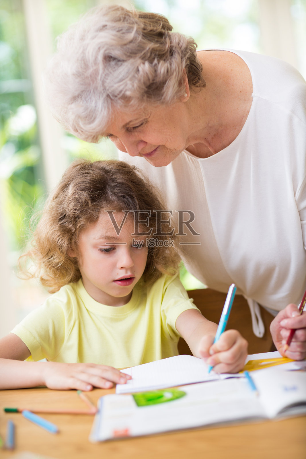 灰奶奶和她可爱的孙子做作业照片摄影图片