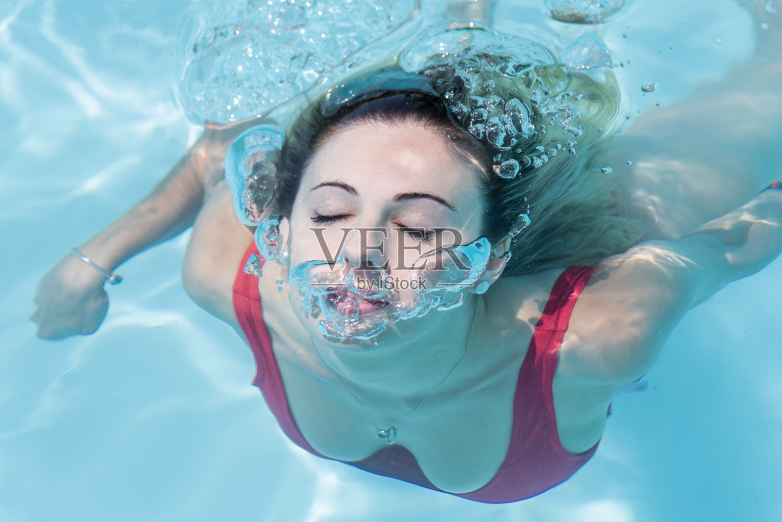 一个女人从游泳池的水下游出来照片摄影图片